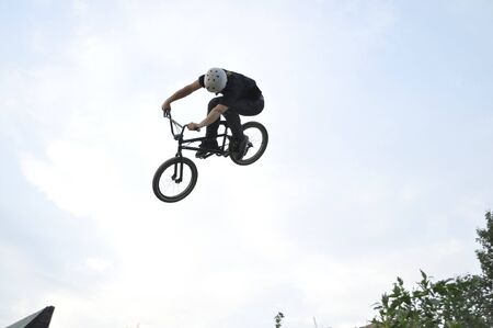 Warsaw, Poland - June 24, 2012: acrobatic BMX rider flies through the air on a bike, during local Dirt jumping game, without an audience, on the outskirts of housing estate.のeditorial素材