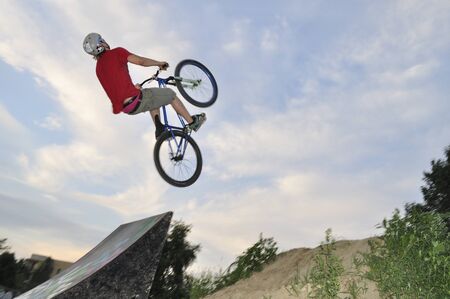Warsaw, Poland - June 24, 2012: acrobatic BMX rider flies through the air on a bike, during local Dirt jumping game, without an audience, on the outskirts of housing estate.のeditorial素材