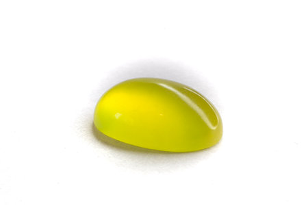 Two Peridots on top of each other on a white background. Olivine oval cut peridot cabochon.の写真素材
