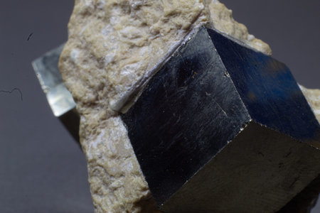 Macro cubical pyrite on white matrix isolated on gray background