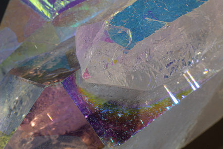 Colourful Angel Aura Quartz crystal point cluster on black surface