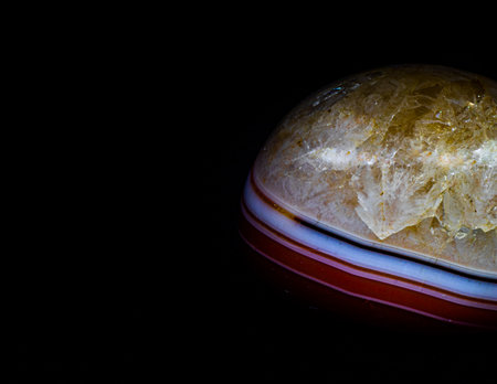 Macro shooting of natural mineral rock specimen - polished quartz gemstone on black backgroundの写真素材