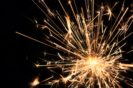 Burning sparkler on a black background, close-up.