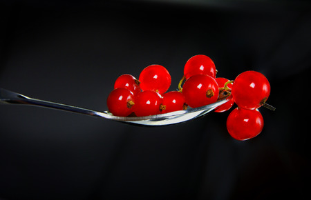 Red currants in spoon on a dark backgroundの写真素材