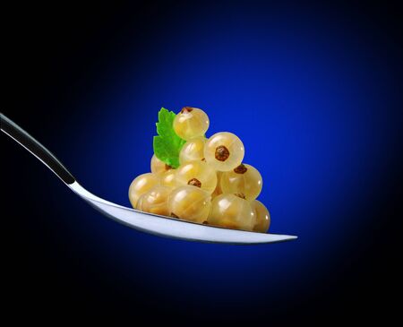 white currants in spoon on a blue backgroundの写真素材