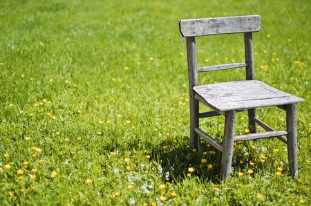 Old wooden chair on green grass.の写真素材