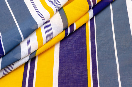 The texture of cotton fabric, batist in blue-white-yellow stripes