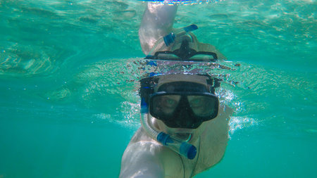 Man with mask snorkeling in clear water. Thailand