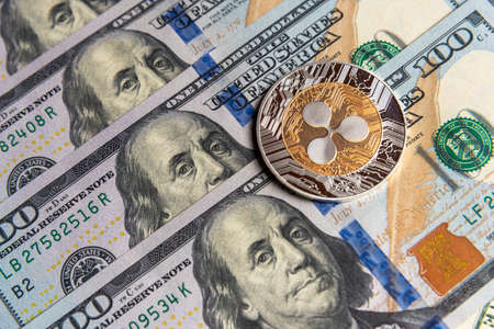 Ripple crypto currency on US dollars. Digital cryptocurrency close-up. Exchange, bussiness, commercial. Profit from mining crypt currencies. Miner with dollars and Ripple coin.の写真素材