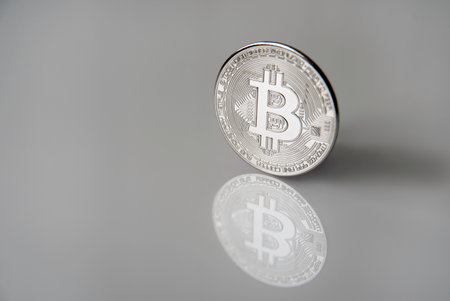 Silver bitcoin coin from cryptocurrency with shadow and isolated gray backgroundの写真素材