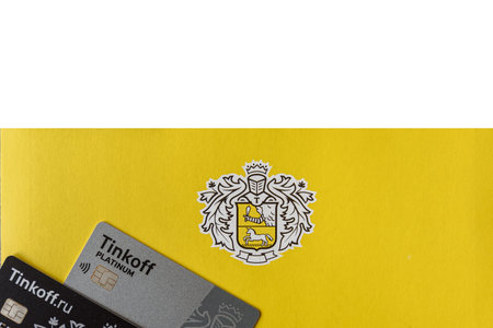 Moscow, Rissia - February 11, 2021: Black and Platinum Tinkoff Bank debit card and corporate yellow envelope (text translation from russian: Tinkoff). Russian commercial bank founded by Oleg Tinkov.のeditorial素材