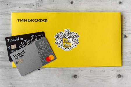 Moscow, Rissia - February 11, 2021: Bitcoin, Black and Platinum Tinkoff Bank debit card and corporate yellow envelope (text translation from russian: Tinkoff). Russian commercial bank founded by Oleg Tinkov.のeditorial素材