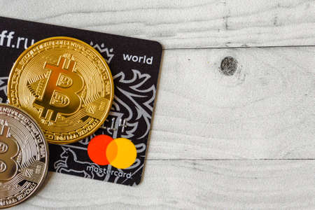 Moscow, Rissia - February 11, 2021: Bitcoin cryptocurrency and Visa, MasterCard debit cards. Visa and MasterCard worldwide is an American multinational financial services corporation against cryptocurrency.のeditorial素材