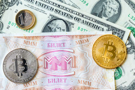 Tickets of the MMM and cryptocurrency coins and dollars. The financial pyramid of MMM was created by Sergei Mavrodi in the 1990s in Russiaの写真素材