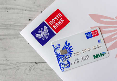 Moscow, Rissia - February 11, 2021: Pochta Bank debit card Mir and corporate logotype of Pochta Bank. Russian commercial bank.のeditorial素材