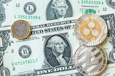 Silver litecoin and ripple and euro coins on paper dollar banknotes. Modern virtual currency digital...