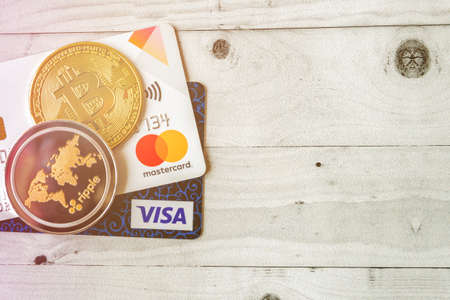 Moscow, Rissia - February 11, 2021: Bitcoin cryptocurrency and Visa, MasterCard debit cards. Visa and MasterCard worldwide is an American multinational financial services corporation against cryptocurrency.のeditorial素材