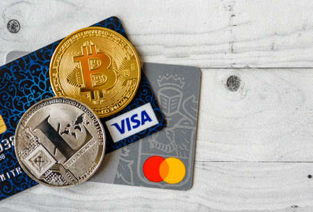 Moscow, Rissia - February 11, 2021: Bitcoin cryptocurrency and Visa, MasterCard debit cards. Visa and MasterCard worldwide is an American multinational financial services corporation against cryptocurrency.のeditorial素材