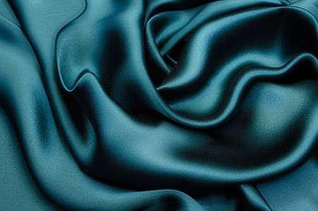Close-up texture of natural green or emerald fabric or cloth in same color. Fabric texture of natural cotton, silk or wool, or linen textile material. Green canvas background.の写真素材