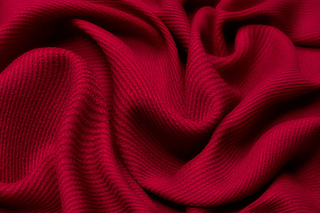 Beautiful draped wool fabric. Red fabric for decoration with decorative folds.