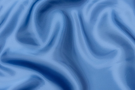 Blue fabric texture background, wavy fabric soft blue color, luxury satin or silk cloth texture.