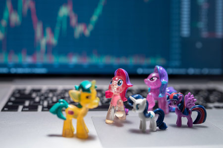 Unicorn toy on laptop on stock market graph background