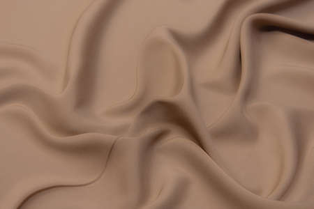 Close-up texture of natural beige or ivory fabric or cloth in brown color. Fabric texture of natural cotton or linen textile material. Beige canvas background.の写真素材