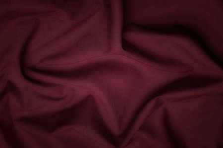 Close-up texture of natural red or pink fabric or cloth in same color. Fabric texture of natural cotton, silk or wool, or linen textile material. Red and orange canvas background.の写真素材