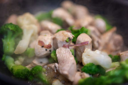 Broccoli fry in a pan with slices of chicken or turkey and onion. Chicken meat with broccoli. Useful lunch.の写真素材