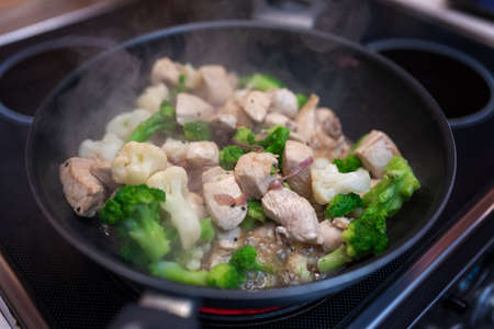 Broccoli fry in a pan with slices of chicken or turkey and onion. Chicken meat with broccoli. Useful lunch.の写真素材