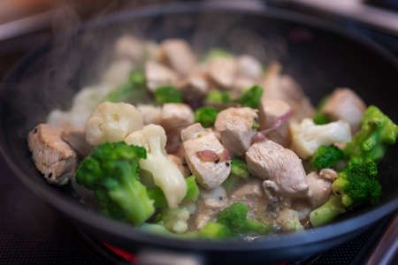 Broccoli fry in a pan with slices of chicken or turkey and onion. Chicken meat with broccoli. Useful lunch.の写真素材