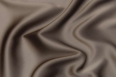 Texture, background, pattern. Texture of peach or beige silk or cotton fabric. Beautiful soft silk or cotton fabric.の写真素材