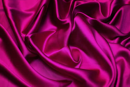 Close-up texture of natural red or pink or fuchsia fabric or cloth in same color. Fabric texture of natural cotton, silk or wool, or linen textile material. Red or pink or fuchsia fabric canvas background.の写真素材