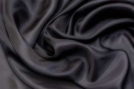 Close-up texture of natural gray or black fabric or cloth in same color. Fabric texture of natural cotton, silk or wool, or linen textile material. Black canvas background.の写真素材