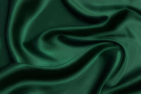 Texture, background, pattern. Texture of green silk fabric. Beautiful emerald green soft silk fabric.の写真素材