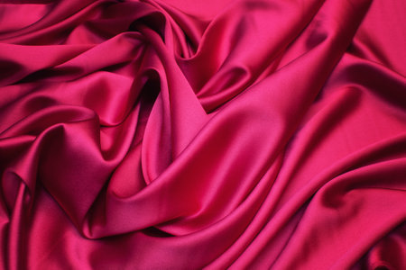 Silk fabric, satin. Color red (pink, fuchsia). Texture, background, pattern.の写真素材