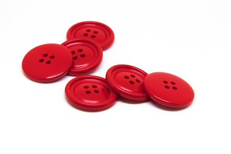 Red buttons for clothes on white background using for concept of Button Day.
