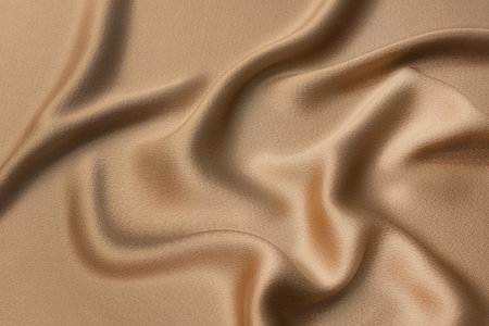 Close-up texture of natural beige fabric or cloth in brown color. Fabric texture of natural cotton or silk textile material. Beige canvas background.の写真素材