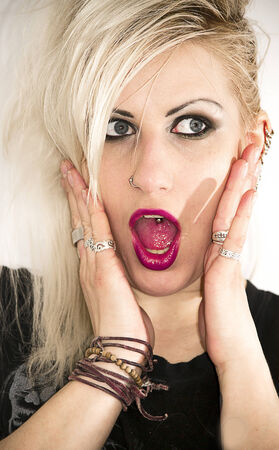 Pretty young blonde girl with piercings screaming の写真素材