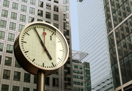 Clock in front a modern buildings in Canary Wharf, east London 