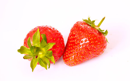Couple of fresh strawberries on a white background の写真素材