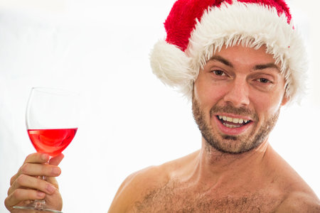 Naughty santa male with a glass of red wine.の写真素材