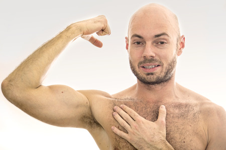 Man showing off his muscles on a white background.の写真素材