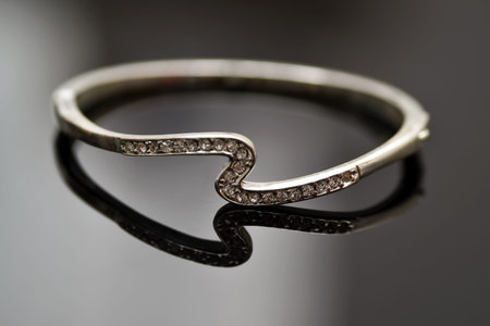 Beautiful silver bracelet on a mirrored glass.