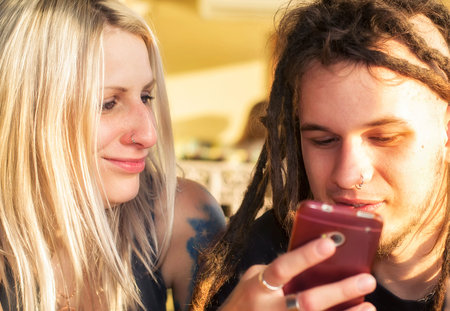 Young alternative couple with a mobile phone.