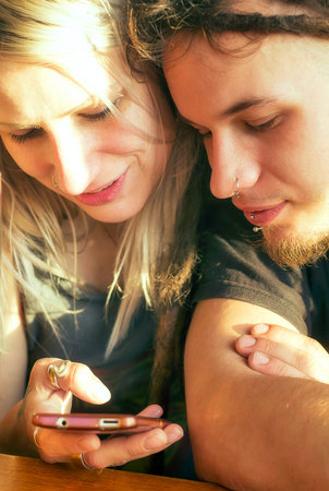 Young couple looking into a mobile phone.