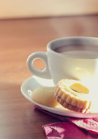 Cup of breakfast tea in a white cup with biscuits.の写真素材