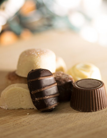 Luxurious chocolate bonbons on a wooden board.