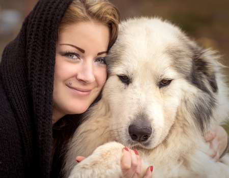 Young woman cuddling a big shepherd dogの写真素材