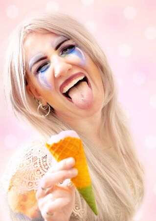 Cute blonde happy woman with colorful makeup up and ice creamの写真素材